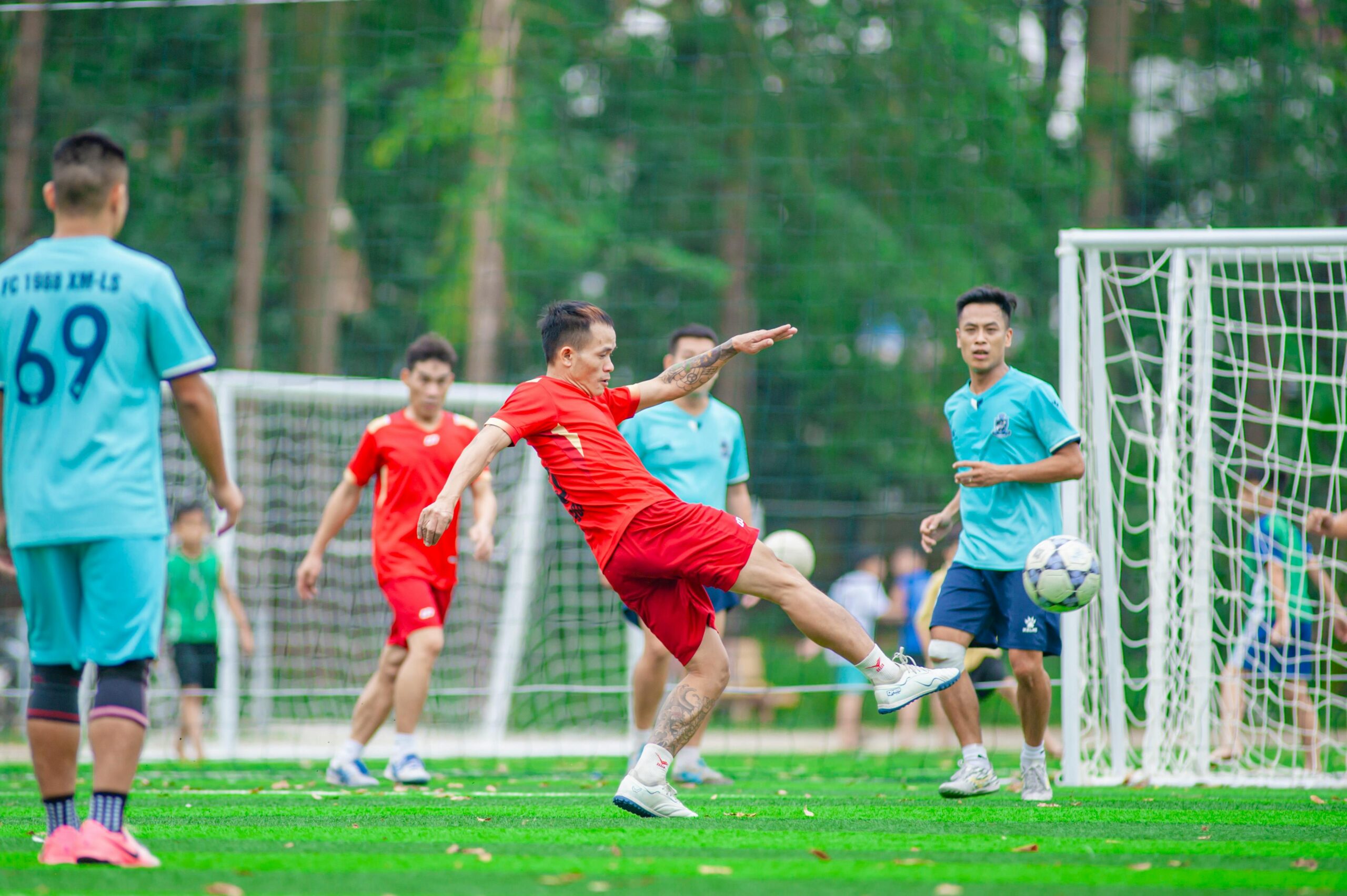 Dynamisches Fußballspiel, aufgenommen im Freien auf einer grünen Wiese in Hanoi, Vietnam.