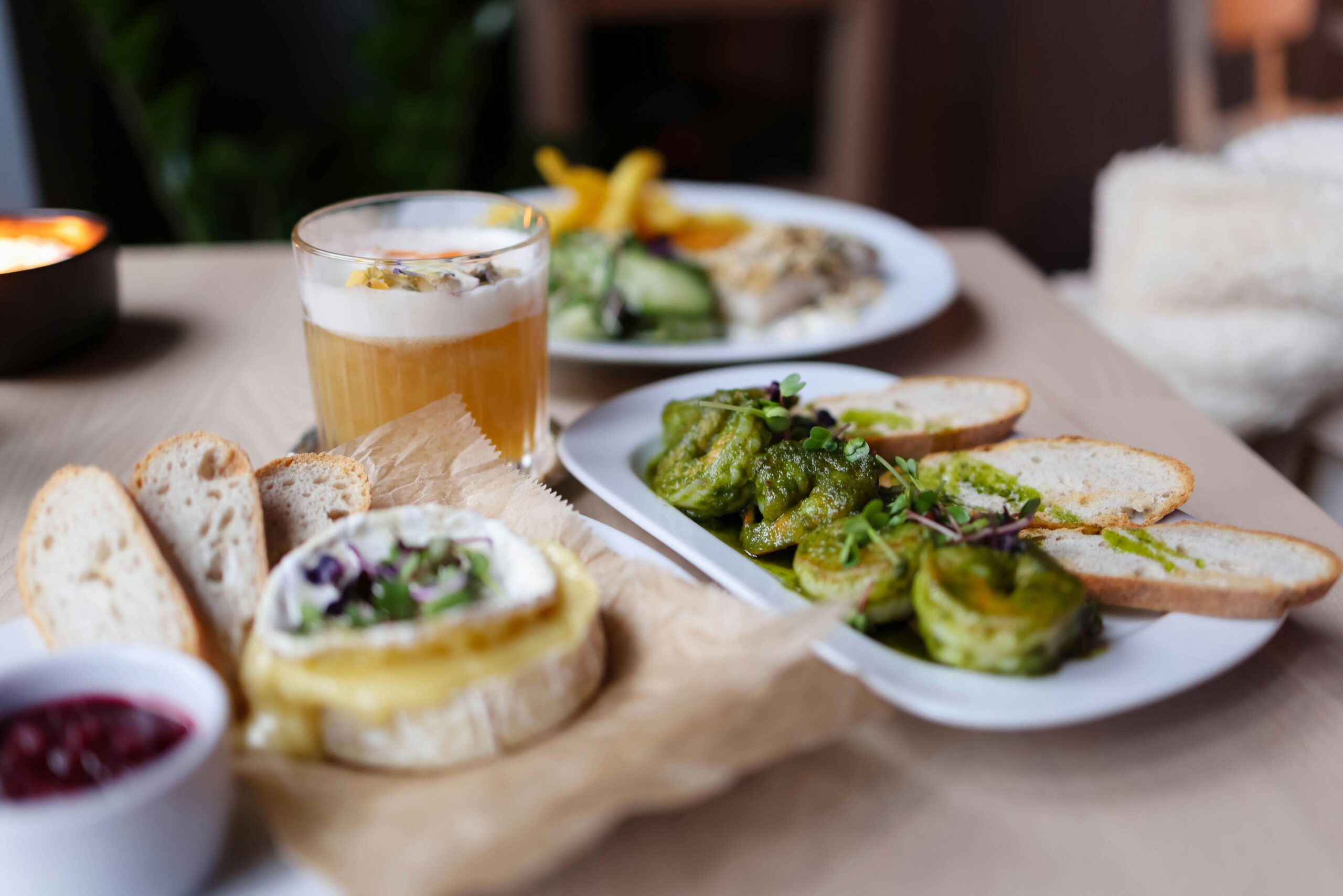 Leckeres vegetarisches Gericht mit Brot, Käse und Gemüse auf einem Holztisch.