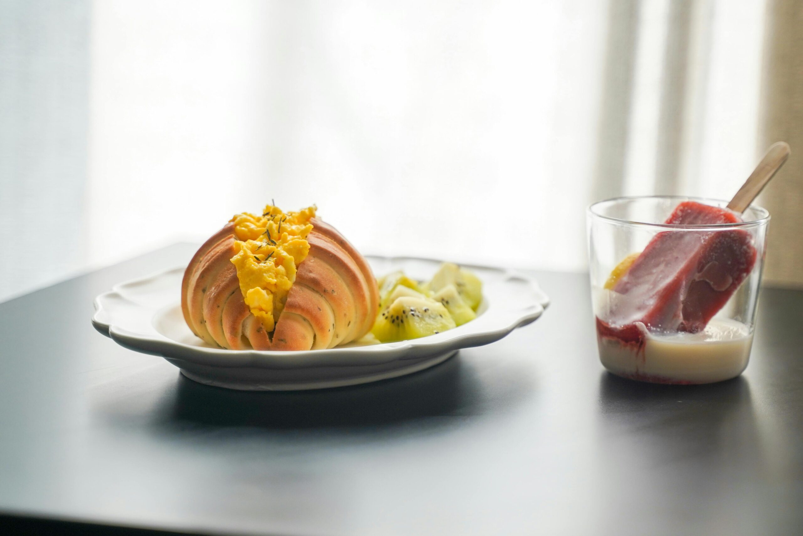 Ein köstliches Frühstücksbuffet mit Gebäck, Kiwischeiben und einem frischen Joghurtgenuss für den Start in den Tag.