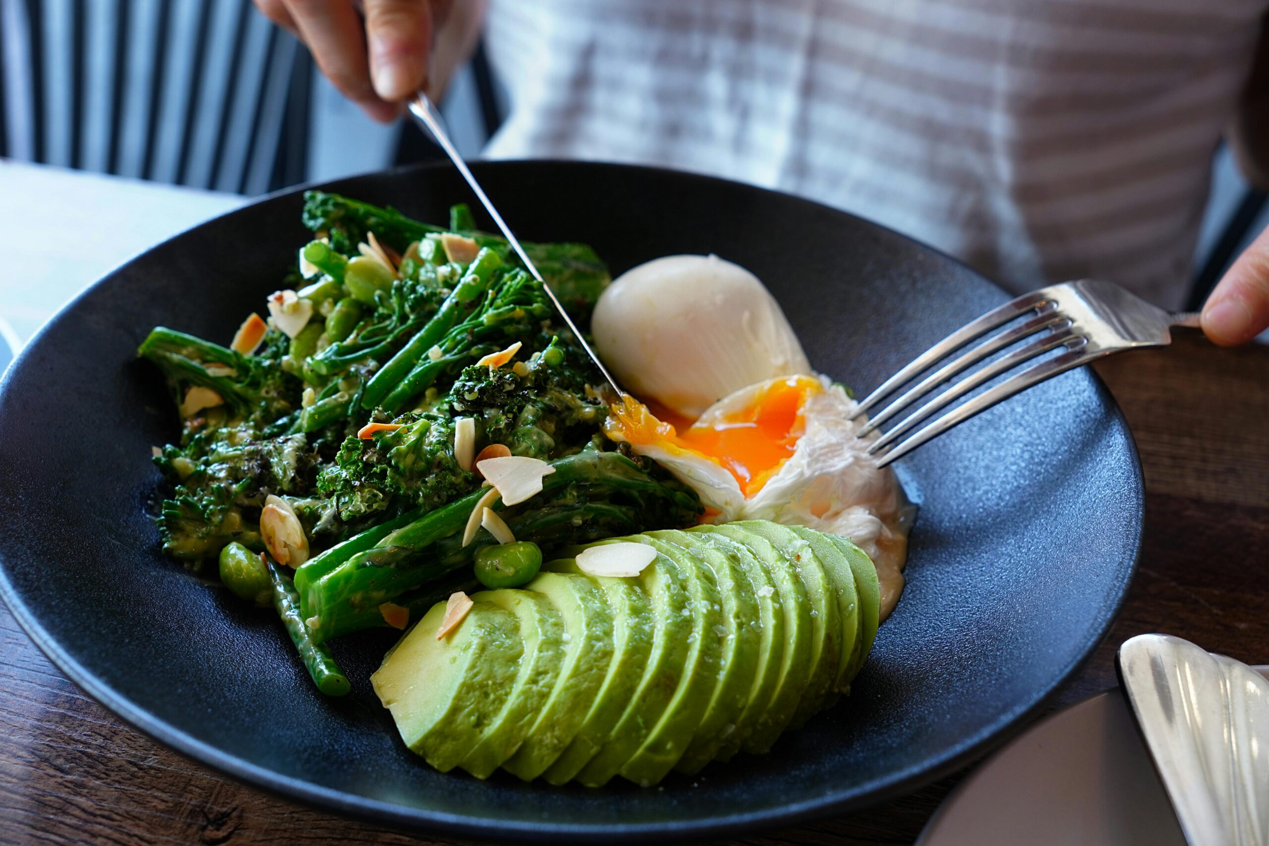 Lebendiges Brunchgericht mit pochiertem Ei, Avocado und Gemüse in einem Café in Sydney.