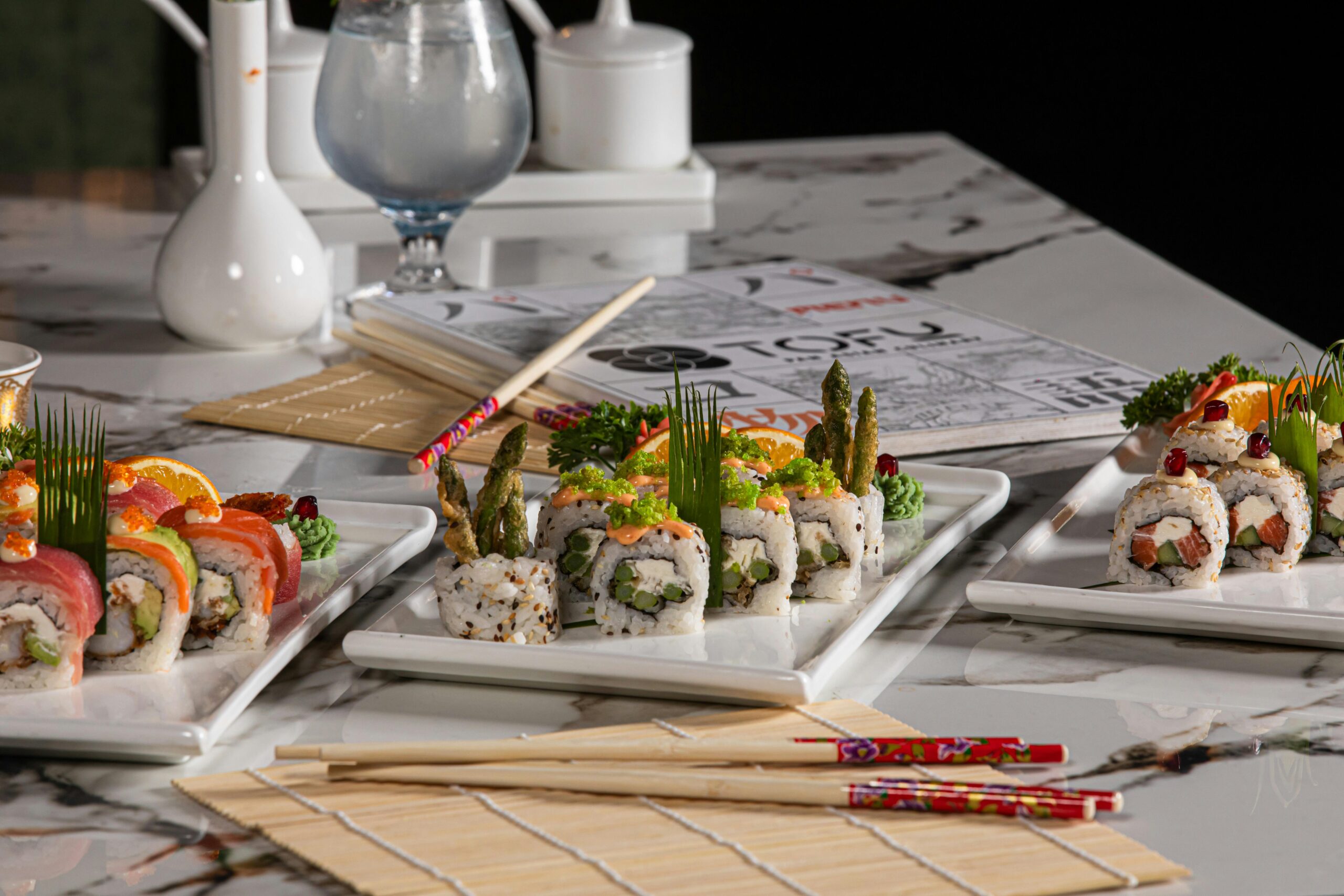 Erfreuen Sie sich an einer elegant angerichteten Platte mit farbenfrohem Sushi, perfekt für ein Gourmet-Essen.