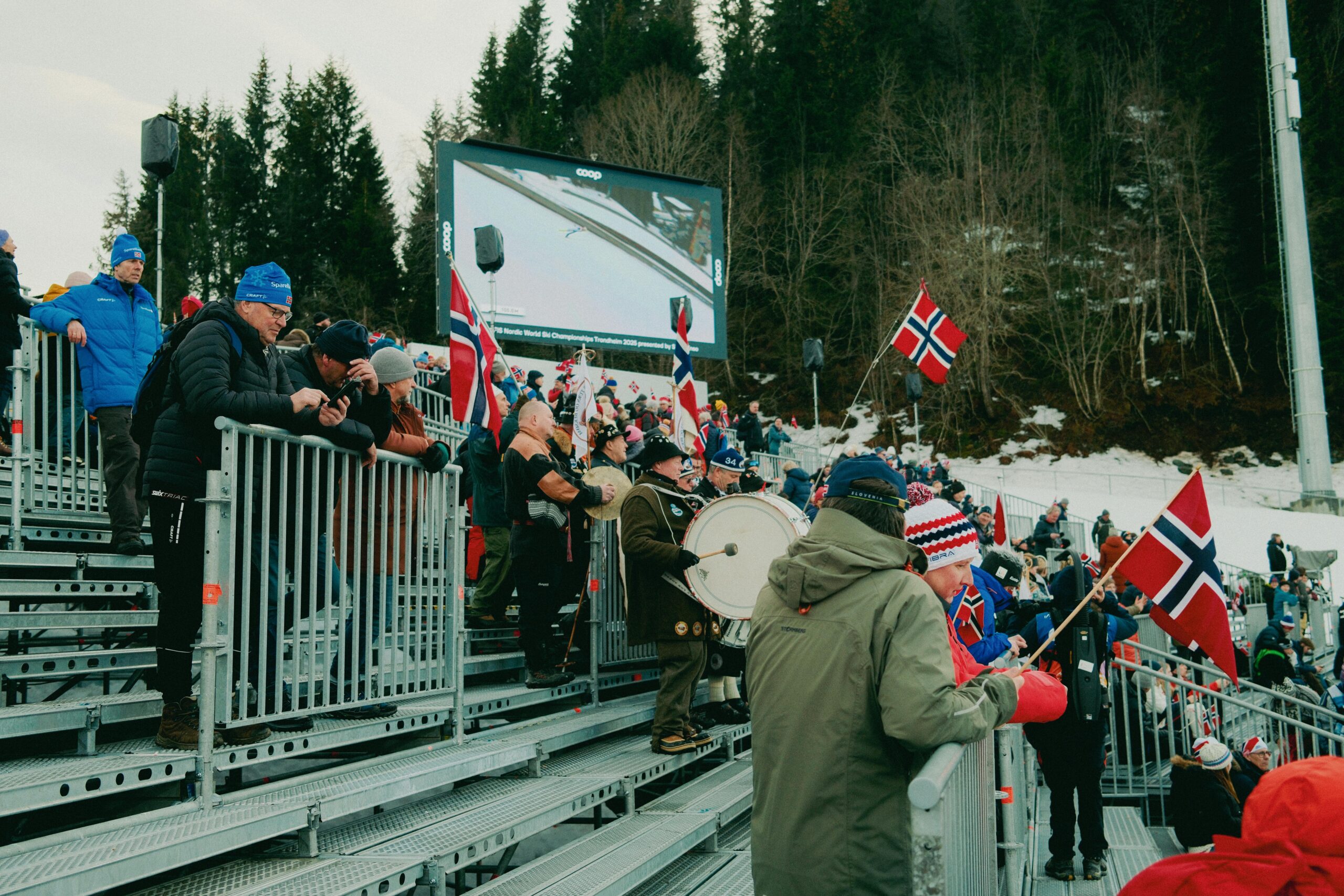 Eine lebhafte Menschenmenge mit Fahnen bei einer Wintersportveranstaltung in Norwegen zeigt ihren Nationalstolz.