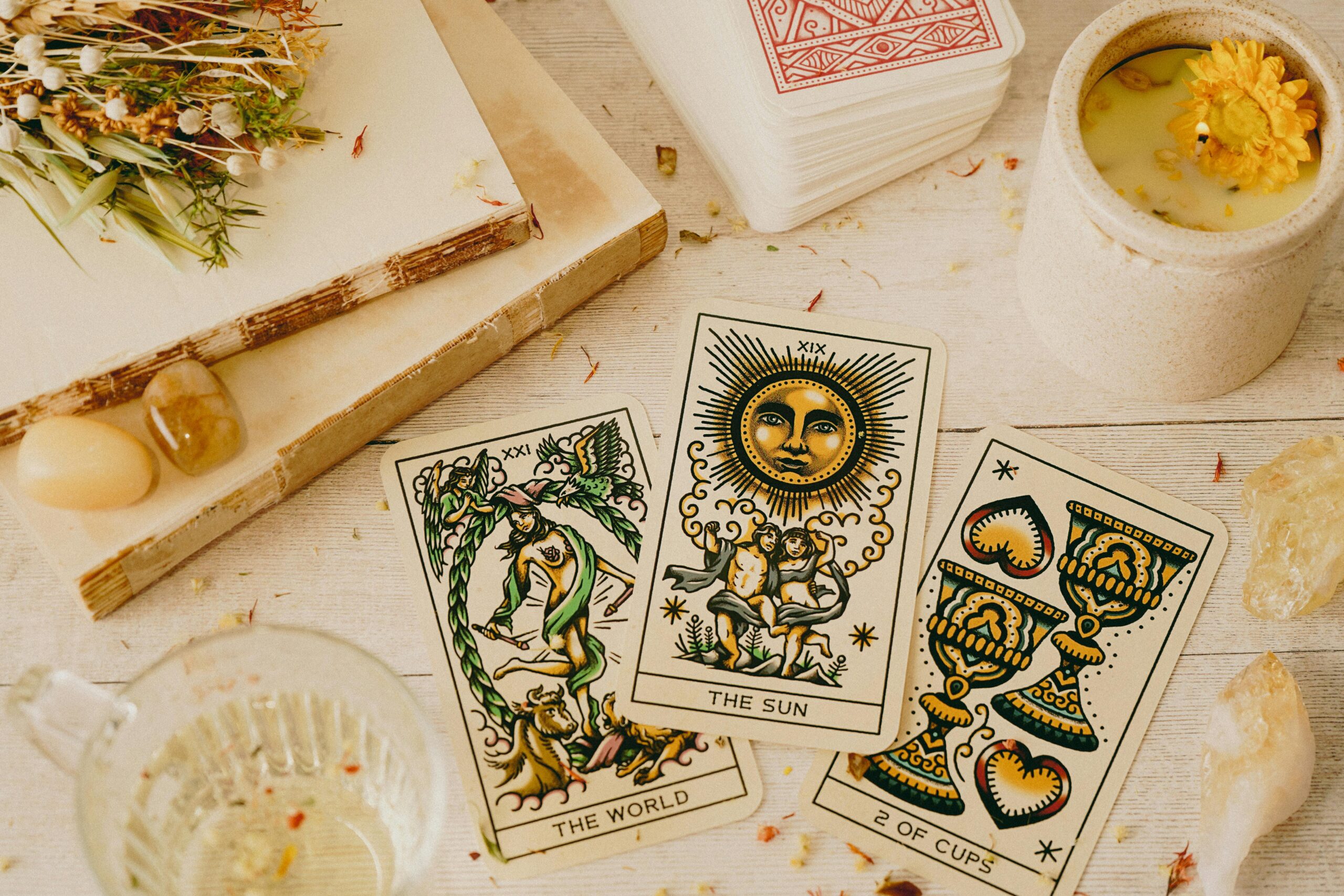 Bezauberndes Tarot-Lese-Setup mit Karten, Kristallen und einer Kerze für eine mystische Atmosphäre.
