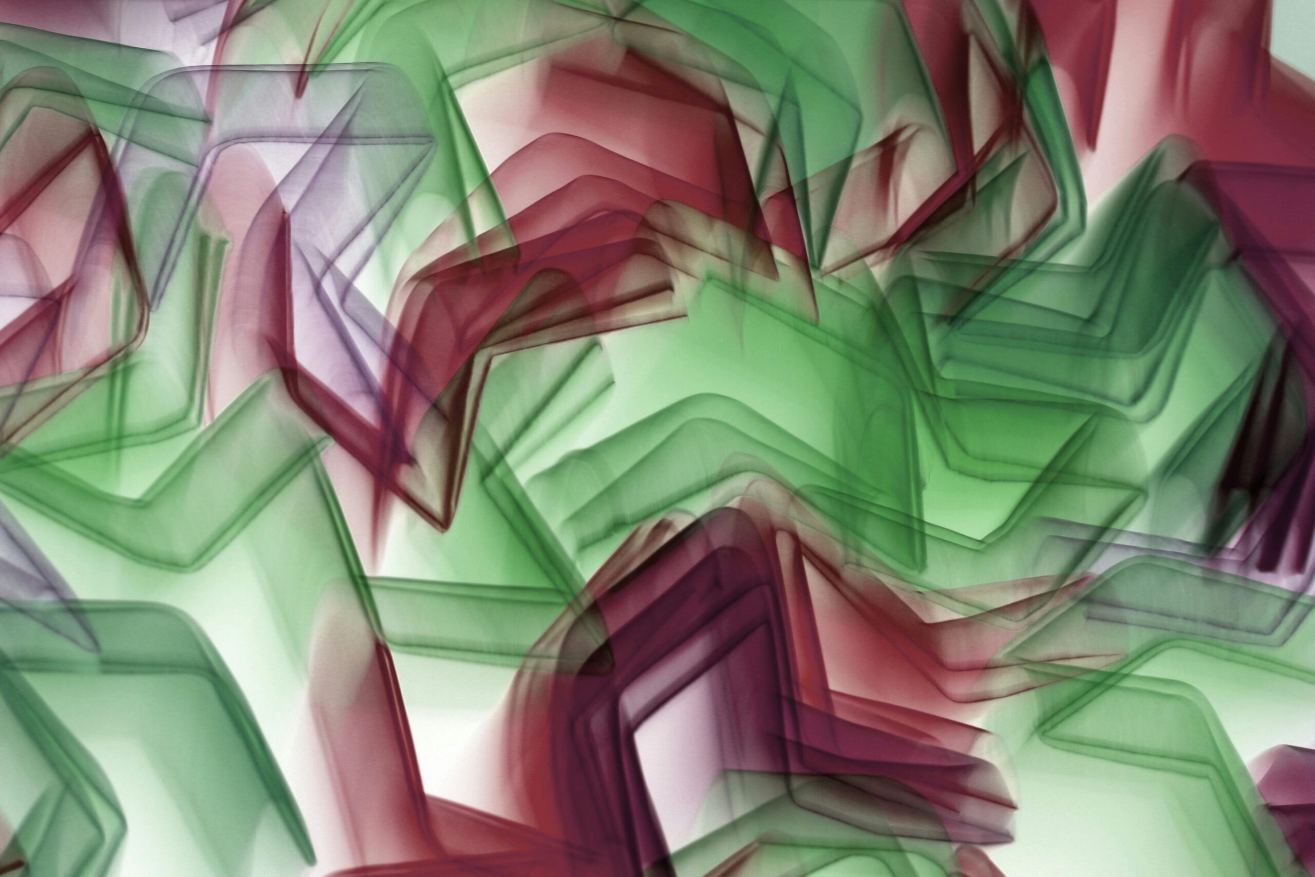 Leuchtende rote und grÃ¼ne abstrakte Formen erzeugen dynamische geometrische Muster.